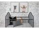 Bedroom with black crib and animal artwork, set against a floral wallpaper backdrop at 2184 Monk Dr, Haw River, NC 27258