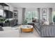 Cozy living room featuring sectional sofa, wood-look floors, and large windows at 2184 Monk Dr, Haw River, NC 27258