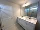 Bathroom featuring double sinks, white cabinetry, quartz countertops, and a glass-enclosed shower at 25 Calabria Ct, Franklinton, NC 27525