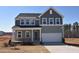 Charming two-story home featuring gray siding, a covered porch, and an attached two-car garage at 25 Calabria Ct, Franklinton, NC 27525