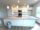 Well-lit kitchen featuring a spacious island, stainless steel appliances, white cabinets, and granite countertops at 25 Calabria Ct, Franklinton, NC 27525