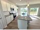 Modern kitchen with stainless steel appliances, granite countertops, white cabinetry, and a view to the outdoors at 25 Calabria Ct, Franklinton, NC 27525