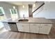 Kitchen island with stainless steel dishwasher, granite countertop, white cabinets, and a sink at 25 Calabria Ct, Franklinton, NC 27525