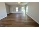 Open-concept living room with wood flooring, neutral paint, and natural light from the windows at 25 Calabria Ct, Franklinton, NC 27525