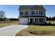 Two-story house with gray siding, a white door, and a curved driveway at 25 Harvest Hills Ln, Dunn, NC 28334