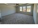 Large main bedroom with gray carpeting and multiple windows at 25 Harvest Hills Ln, Dunn, NC 28334
