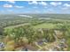 Scenic aerial view of a neighborhood surrounded by lush green trees and a calm lake in the distance at 2721 Sanctuary Woods Ln, Raleigh, NC 27606
