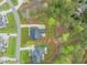 Aerial view of the home and the neatly landscaped backyard and patio with mature trees and surrounding homes at 2721 Sanctuary Woods Ln, Raleigh, NC 27606