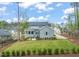 Expansive, lush backyard with mature trees, manicured landscaping, and a charming patio area at 2721 Sanctuary Woods Ln, Raleigh, NC 27606