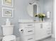 Stylish bathroom with white vanity, round mirror, and gray walls at 2721 Sanctuary Woods Ln, Raleigh, NC 27606