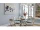 Elegant dining area with modern chandelier, art, and a glass table setting at 2721 Sanctuary Woods Ln, Raleigh, NC 27606