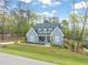 Beautiful blue brick home with a landscaped yard and a covered front porch with rocking chairs at 2721 Sanctuary Woods Ln, Raleigh, NC 27606