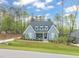 Beautiful blue brick home with a landscaped yard and a covered front porch with rocking chairs at 2721 Sanctuary Woods Ln, Raleigh, NC 27606