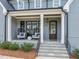 Charming front porch featuring rocking chairs, stone steps, and an elegant front door with sidelights at 2721 Sanctuary Woods Ln, Raleigh, NC 27606