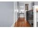 Hallway features hardwood floors, soft blue walls and modern railing leading to the upper level at 2721 Sanctuary Woods Ln, Raleigh, NC 27606