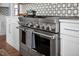 Close up view of a stainless-steel range with black and white tile backsplash at 2721 Sanctuary Woods Ln, Raleigh, NC 27606