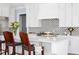 Gourmet kitchen with white cabinets, tiled backsplash, and a large island at 2721 Sanctuary Woods Ln, Raleigh, NC 27606