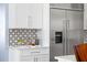 Modern kitchen features stainless steel refrigerator, white cabinetry and backsplash with marble countertops at 2721 Sanctuary Woods Ln, Raleigh, NC 27606