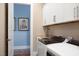 Modern laundry room with white cabinets, sink, and front-loading washer and dryer at 2721 Sanctuary Woods Ln, Raleigh, NC 27606