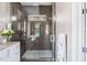 Contemporary shower featuring dark gray tile, glass door, and built-in shelving at 2721 Sanctuary Woods Ln, Raleigh, NC 27606