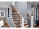 Staircase features wood steps, sleek black railings and abundant natural light, complementing the home's modern aesthetic at 2721 Sanctuary Woods Ln, Raleigh, NC 27606