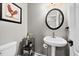 Half bathroom with a pedestal sink, decorative mirror, and a framed rooster painting at 3020 Imperial Oaks Dr, Raleigh, NC 27614