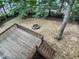 A spacious backyard view from the wooden deck highlighting the stone fire pit and verdant landscape at 408 Froyle Ct, Rolesville, NC 27571