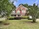 A two-story brick house has manicured landscaping and an attached garage at 408 Froyle Ct, Rolesville, NC 27571