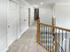 Hallway with stairs featuring wood and iron banister and multiple storage closets at 408 Froyle Ct, Rolesville, NC 27571