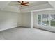 Unfurnished main bedroom featuring a tray ceiling, ceiling fan, and a large window at 408 Froyle Ct, Rolesville, NC 27571