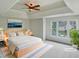 Serene main bedroom boasts a tray ceiling, a ceiling fan, and a large window at 408 Froyle Ct, Rolesville, NC 27571
