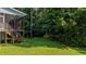 Large grassy backyard featuring a sloped terrain and surrounded by a dense forest at 46 Trusting Ln, Middlesex, NC 27557