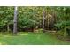 Large grassy backyard surrounded by dense forest, featuring multiple bird houses attached to trees at 46 Trusting Ln, Middlesex, NC 27557