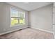 Bright bedroom features neutral walls, plush carpet, and a window with scenic outdoor views at 46 Trusting Ln, Middlesex, NC 27557