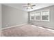 A simple bedroom with carpet, a ceiling fan, and bright light through a window at 46 Trusting Ln, Middlesex, NC 27557