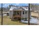 Gray house with a deck and screened porch, surrounded by trees and a yard at 46 Trusting Ln, Middlesex, NC 27557