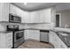 Modern kitchen featuring white cabinets, stainless steel appliances, and granite countertops at 46 Trusting Ln, Middlesex, NC 27557
