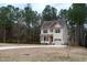 Two-story house with beige siding, red roof accents, and a two-car garage at 496 Omaha Dr, Broadway, NC 27505