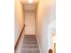 View of home staircase with carpeted steps, wood railing, and neutral paint colors at 496 Omaha Dr, Broadway, NC 27505