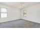 Bright bedroom with grey carpet, ceiling fan and two windows at 502 Randolph Dr, Clayton, NC 27520