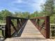 Wooden footbridge with metal railings, offering scenic views at 5112 N River Sand Trl, Raleigh, NC 27604