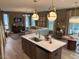 Open floor plan with kitchen island, living room, and hardwood floors at 5112 N River Sand Trl, Raleigh, NC 27604