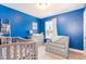 Bedroom with blue walls, charming decor, and a comfortable seating area at 57 Duchess Ave, Franklinton, NC 27525