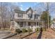 Two-story house with gray siding, white porch, and landscaping at 6224 Bridgemont Ln, Willow Springs, NC 27592