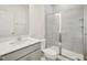 Modern bathroom with tiled shower, glass doors, vanity with countertop, and white toilet at 92 Frost Meadow Way, Lillington, NC 27546
