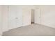 Carpeted bedroom with double doors and a view into the next room; bright and airy at 92 Frost Meadow Way, Lillington, NC 27546