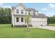 Attractive two-story home featuring a three-car garage and a manicured front yard at 92 Frost Meadow Way, Lillington, NC 27546