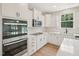 Modern kitchen with stainless steel appliances, white cabinets, and quartz countertops at 92 Frost Meadow Way, Lillington, NC 27546