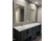 Double vanity bathroom with gray cabinets and a large mirror at 1039 Branch Chapel Church Rd, Selma, NC 27576