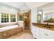 Elegant bathroom featuring a soaking tub, glass-enclosed shower, and granite vanity, providing a luxurious retreat at 11201 Jonas Ridge Ln, Raleigh, NC 27613
